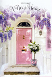 Outside a cosy home in Grove Park, a gentle scene of welcome unfolds around a pastel pink front door, its surface glowing softly against the surrounding whitewashed walls. Above, and draping slightly to the sides, lush wisteria cascades in tumbling trails of lavender and soft purple, the dangling flower clusters creating a natural canopy that calls to mind the leafy tranquillity along the Thames towpath. The wisteria's light, feathery foliage filters the sunlight, casting subtle, shifting shadows over the door and a single coordinating shutter painted in a complementary hue. At the base of the doorway, a simple metal bucket sits squarely on the step, repurposed by a florist into a generous bouquet that brims with white and creamy roses. Each rose is full and velvety, its petals curling outward like small, layered shells, interlaced with touches of fresh, soft green foliage that add depth and a relaxed elegance. Around the bucket's base, a blush-pink ribbon is carefully tied, the bow's loops and trailing ends echoing the door's warm tone and adding a hint of celebration. The overall light is mellow and inviting, suggesting a mild afternoon as someone waits just inside to greet their first guests. The composition feels tender, intimate, and hopeful, perfect for congratulating a loved one on their new home in Grove Park. It conveys the sense of a thoughtful floral delivery left right at the threshold, ready to fill an empty hallway with fragrance, softness, and the reassuring feeling that this charming, blossom-framed doorway marks the start of many happy memories.